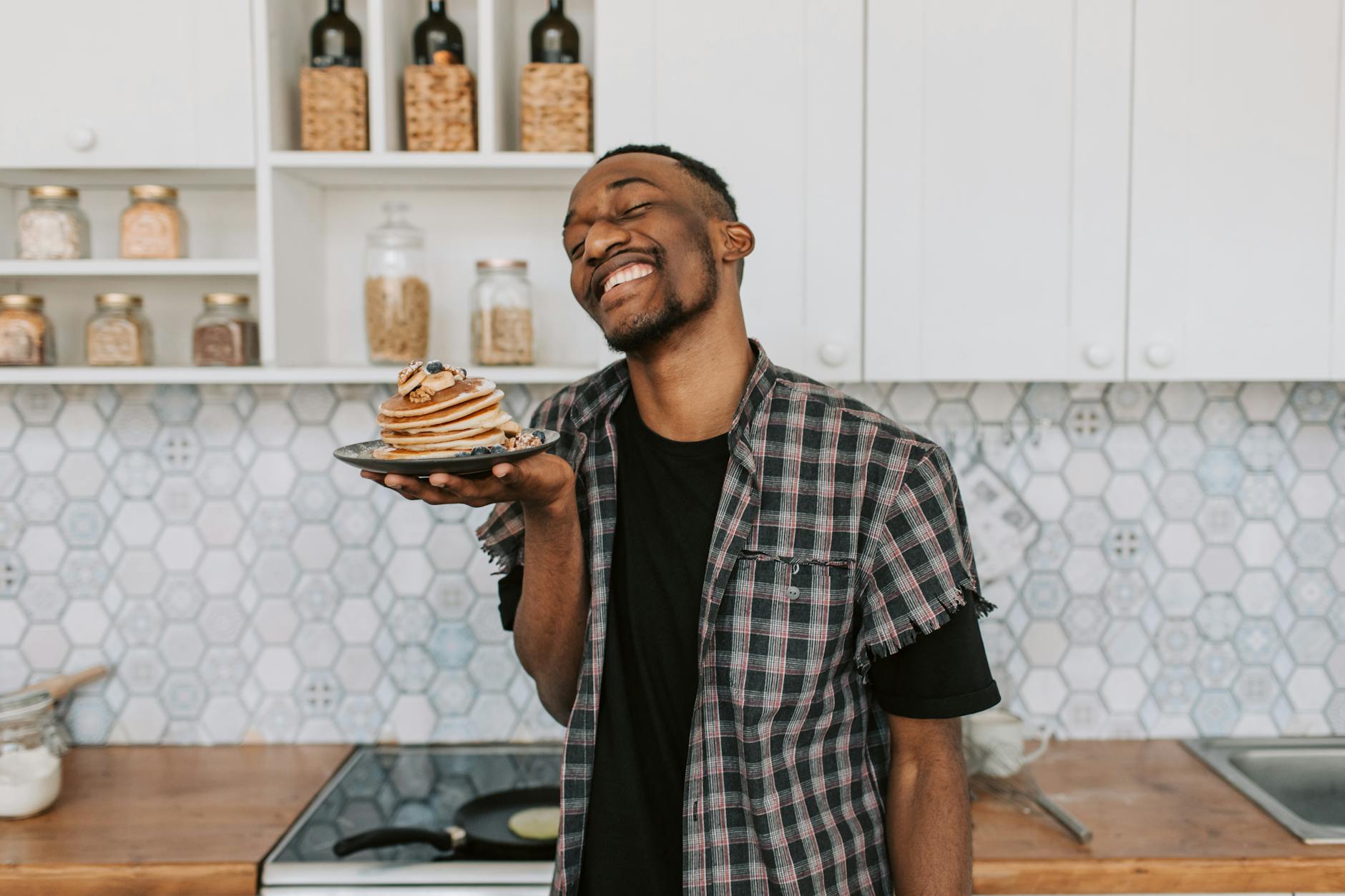 happy man holding a plate with pancakes